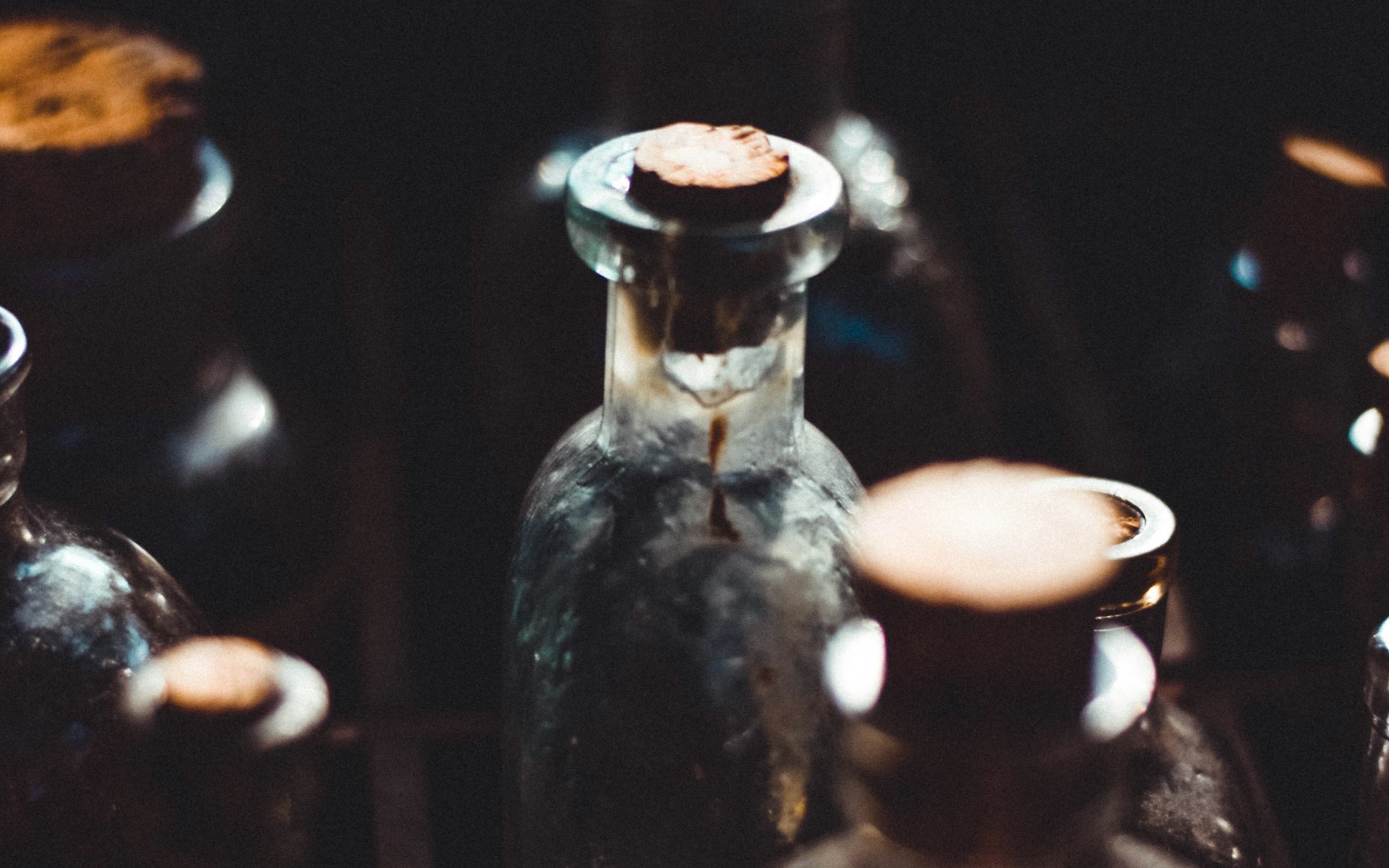 Glass bottles and vials on a dark workbench