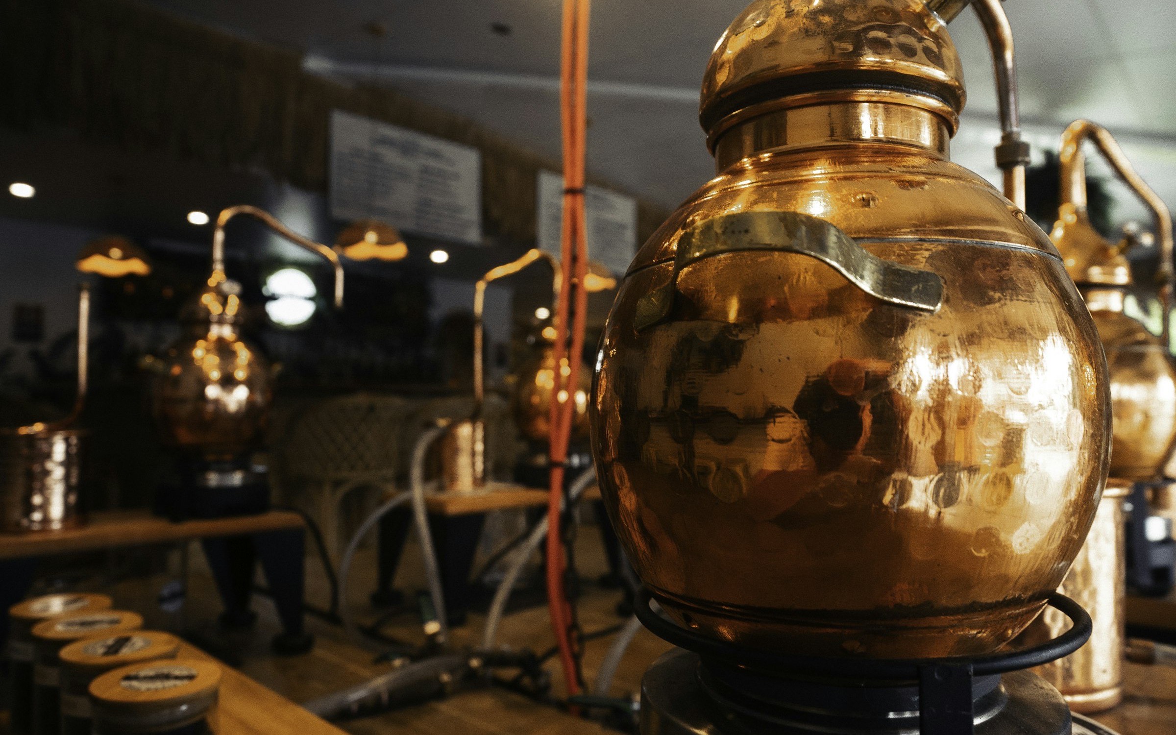 Copper distillation stills glowing in a dark room
